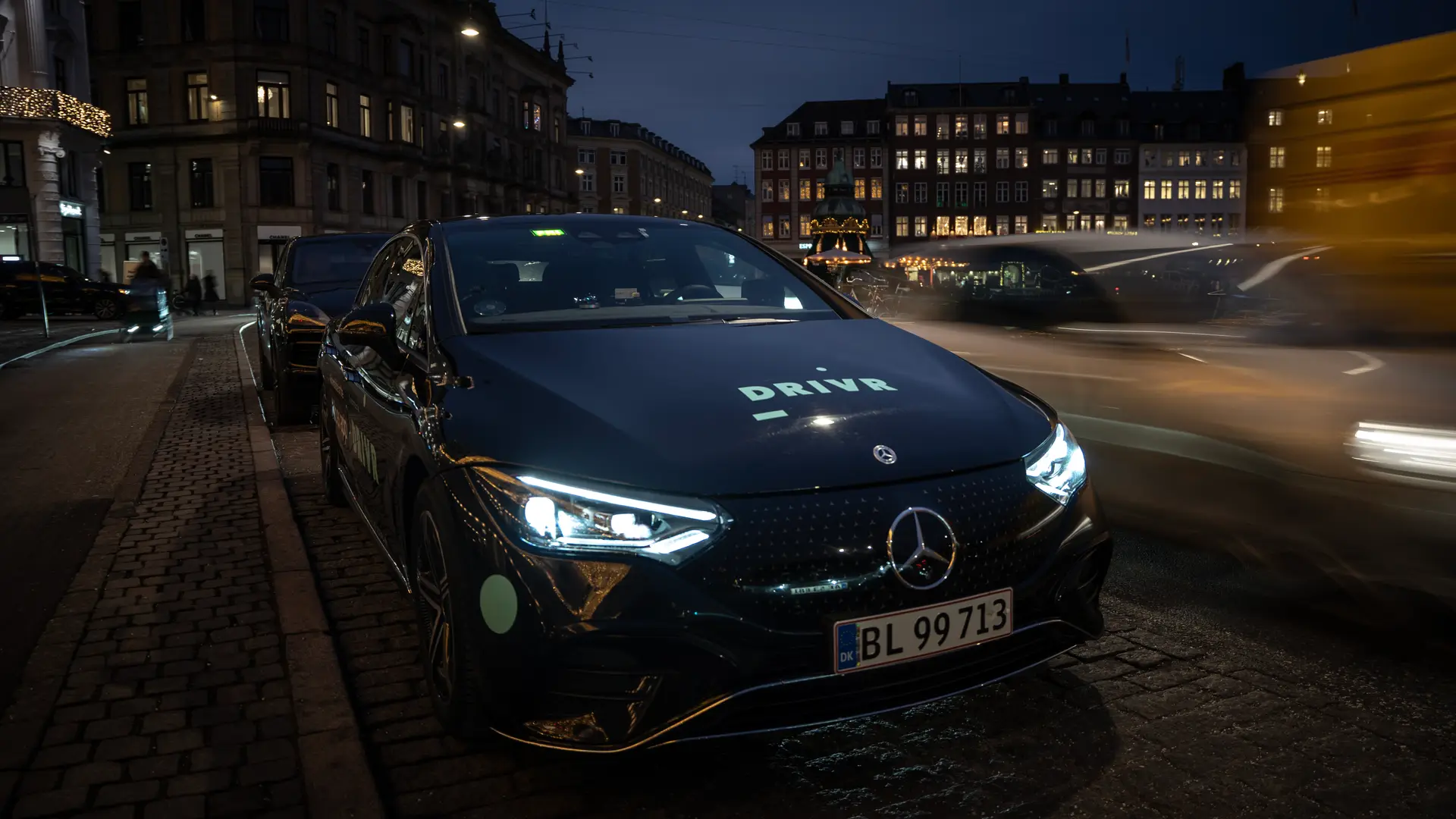 DRIVR eltaxi med tændte lygter om aftenen